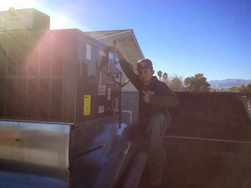HVAC technician performing HVAC Inspection on a rooftop unit in Jasper